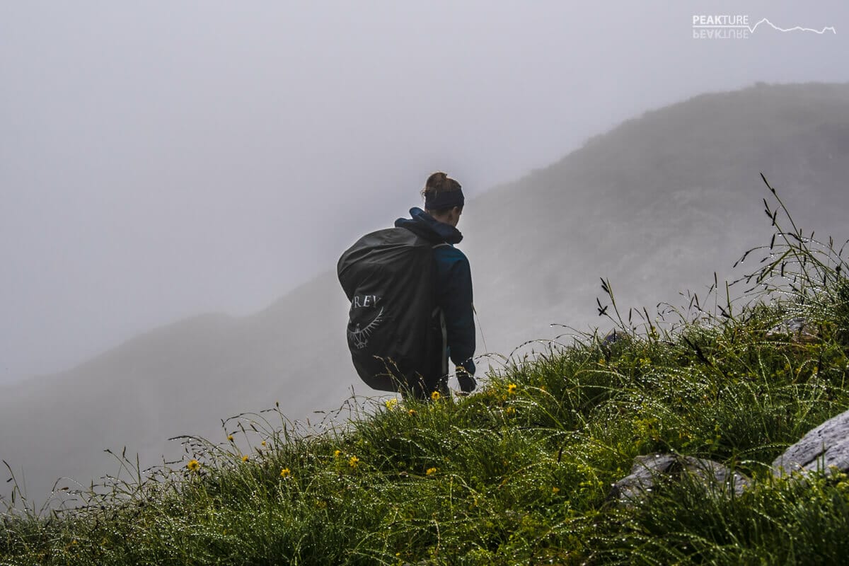 Bergsteigerin vor Nebelwand auf einer Bergtour in Ellmau