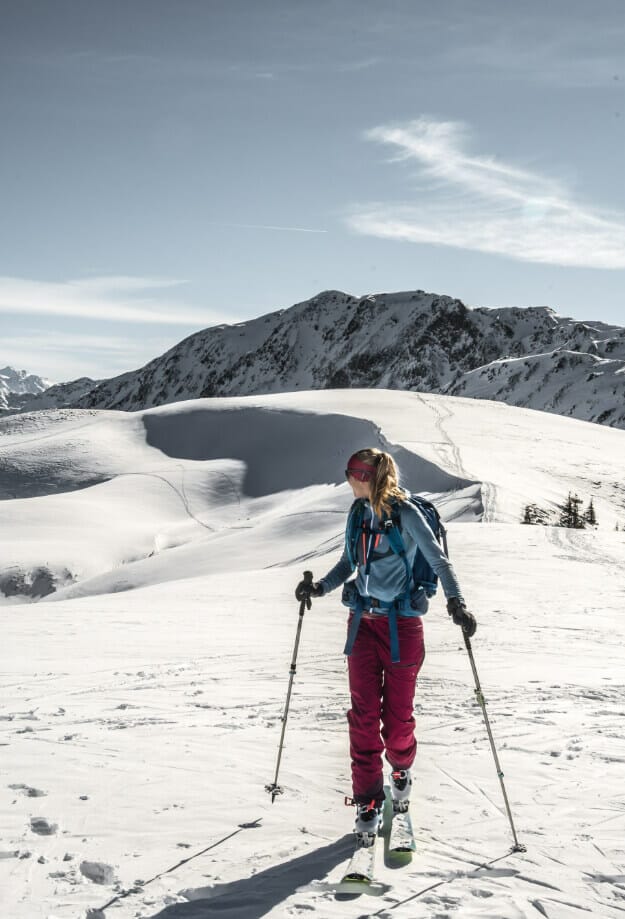 Frau blickt zurück zur Aufstiegsspur der Skitour zum Lodron. Eine schöne verschneite Winterlandschaft
