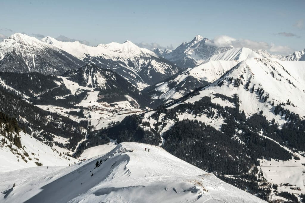 Rückblick auf dem Bergrücken, kurz vor dem Galtjoch. Zwei Skitourengeher in der Ferne sichtbar. Der Rücken ist komplett eingeschneit.