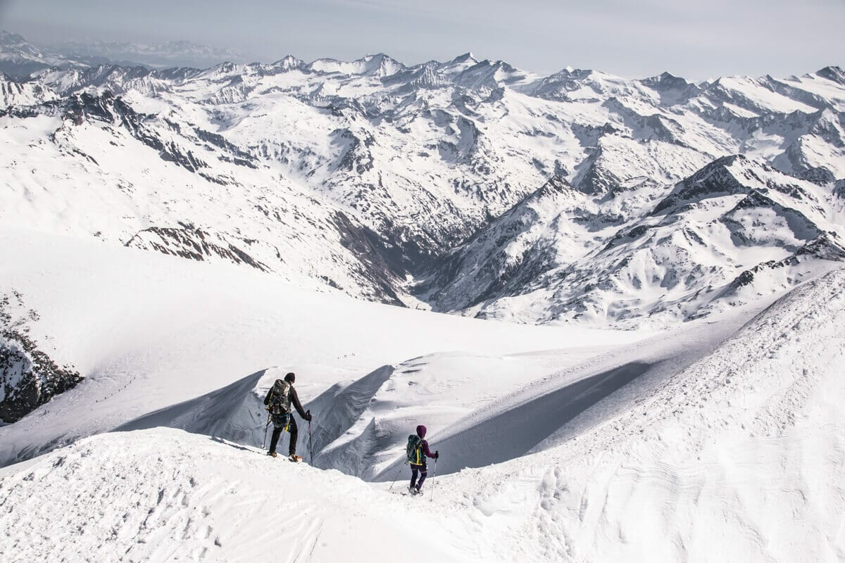 Zwei Personen steigen vom Grossvenediger mit Schneeschuhen ab über eine bezaubernde Winterlandschaft