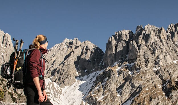 Bergsteigerin mit Blick Richtung Kaisergebirge