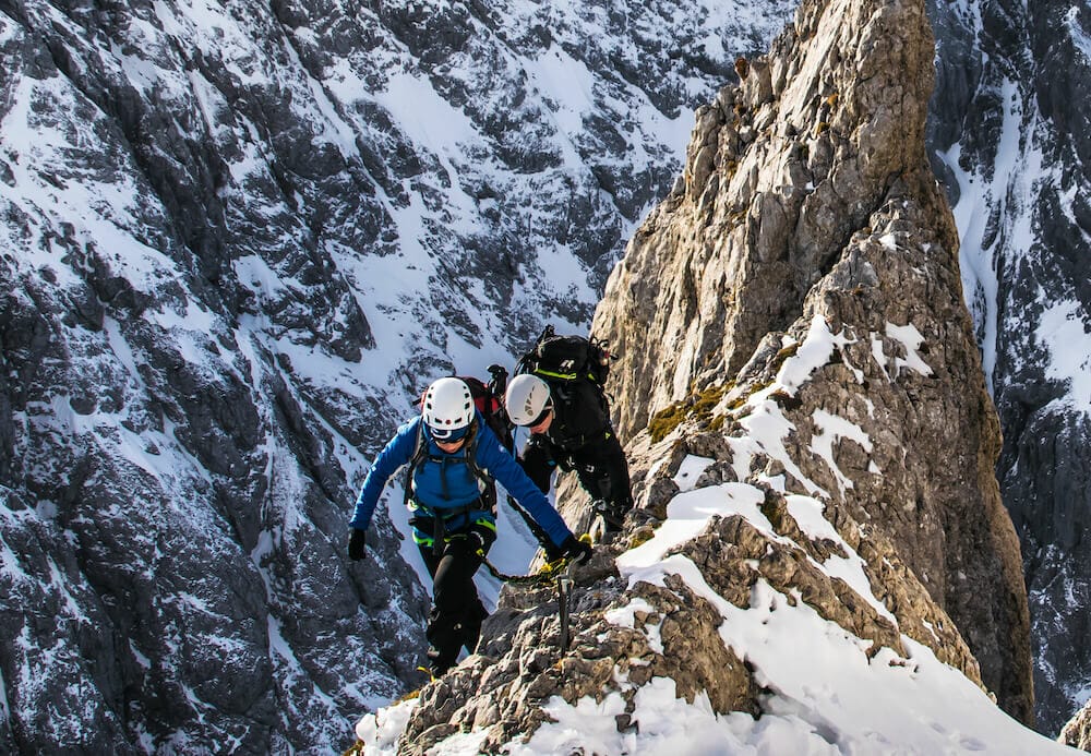 zwei Bergsteiger im sehr steilen Berggelände in der Winterzeit