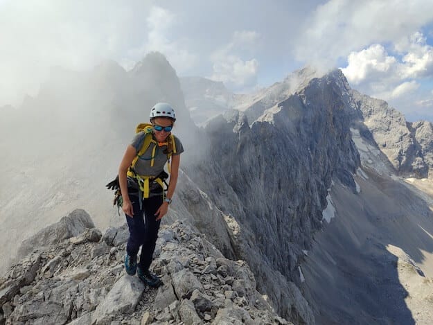 Bergsteigerin in den Alpen auf einem Grat.