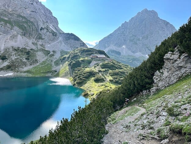 Bergsee mit Berghütte im Sonnenlicht